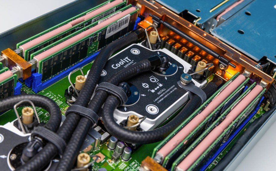 Liquid-cooled server interior with CoolIT cold plate, braided coolant lines, and DIMM slots.